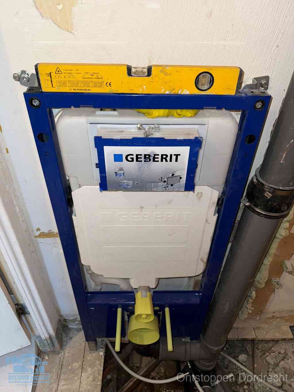 Een Geberit inbouwreservoir met frame voor een hangtoilet tegen de wand, met de afvoerbocht naar de vloer, kenmerkend voor een verstopt hangtoilet in Dordrecht