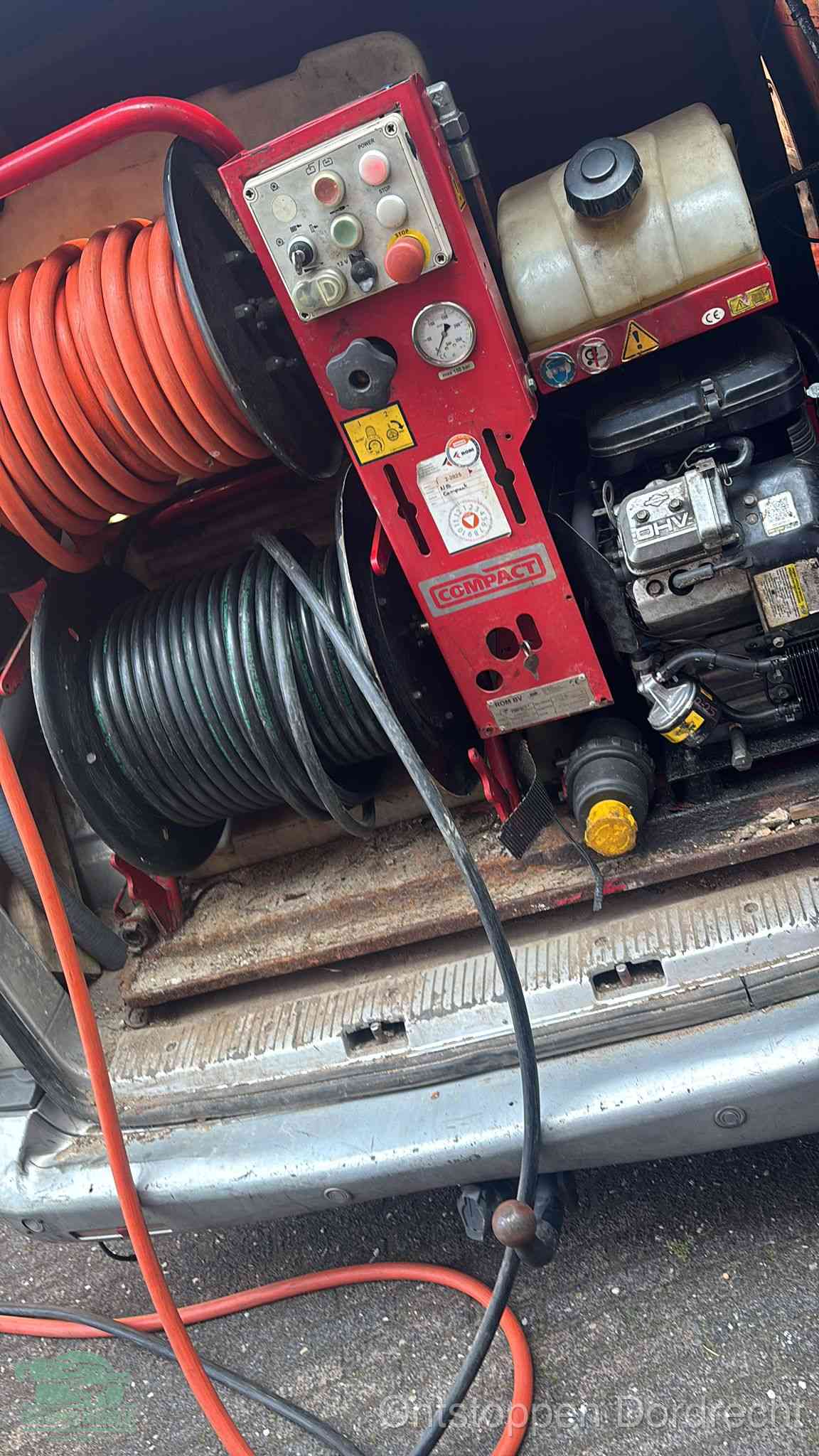 Een rood hogedruk-rioolreinigingstoestel in de laadbak van de bedrijfsbus, apparatuur voor een hardnekkige afvoerverstopping in Dordrecht