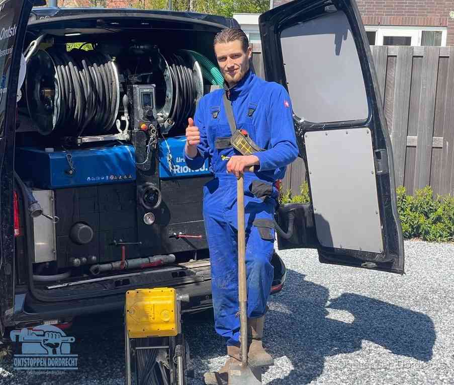 Een monteur bij de werkbus met grote hogedruk-slanghaspels, apparatuur voor hardnekkige afvoerverstoppingen in Dordrecht