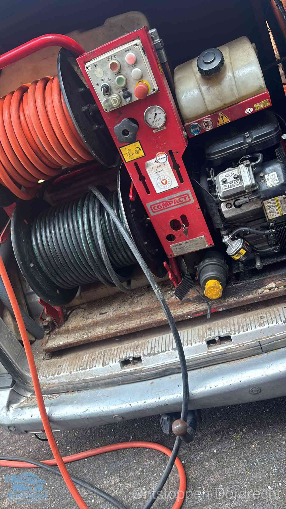 Een rood hogedruk-rioolreinigingstoestel met slangen in de laadbak van de bedrijfsbus, apparatuur voor een hardnekkige wc-verstopping in Dordrecht