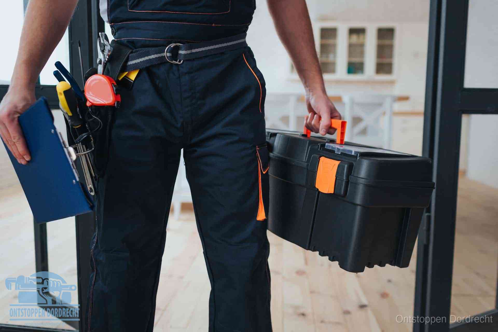 Een monteur met gereedschapsriem en klembord in een keuken, klaar om een transparante prijs voor het gootsteen ontstoppen in Dordrecht te geven