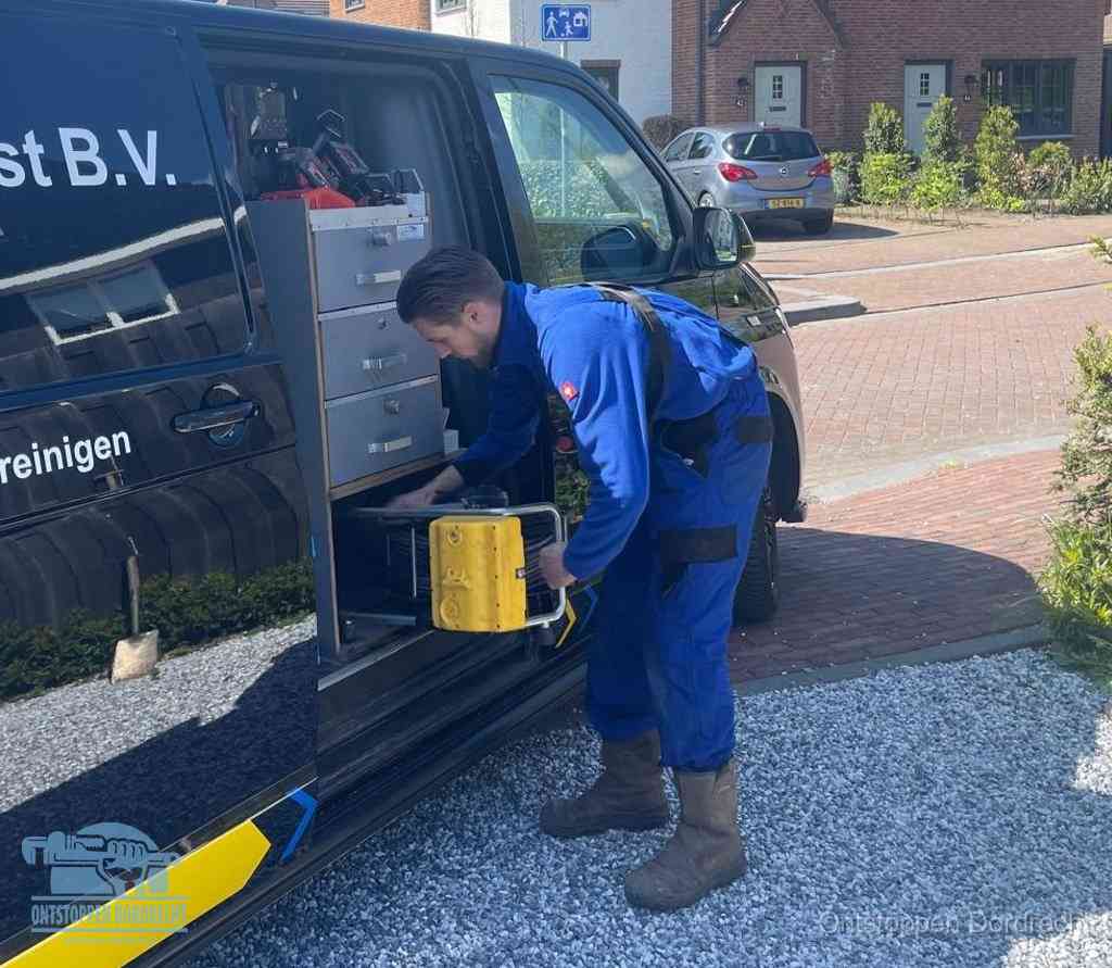 Een monteur pakt apparatuur uit de bedrijfsbus voor service aan huis, het moment om een professional in te schakelen voor een verstopte wc in Dordrecht