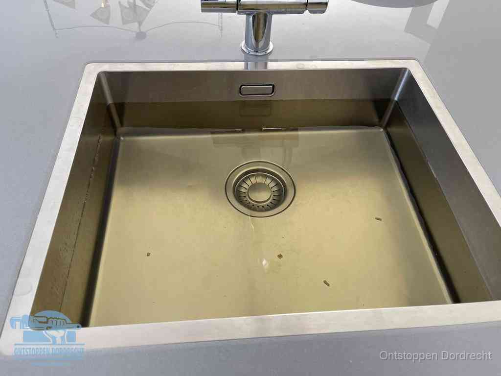 Stilstaand water in een rvs spoelbak dat niet wegloopt, een duidelijk signaal van een gootsteenverstopping in Dordrecht
